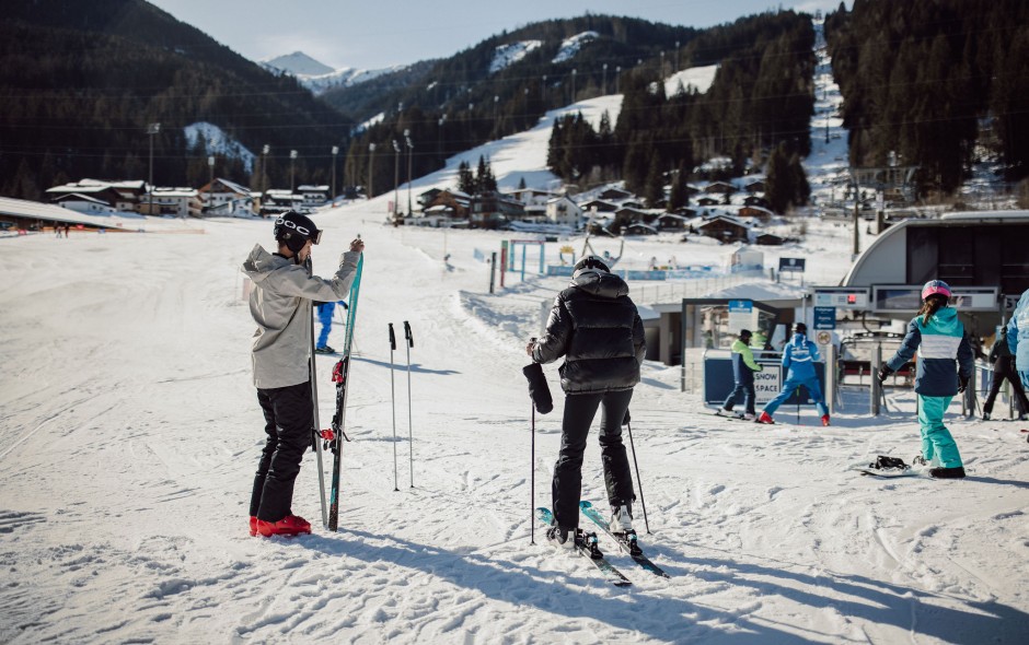 Skifahrer bereiten sich an der Talstation in Flachau im Skigebiet Ski amadé auf die Abfahrt vor