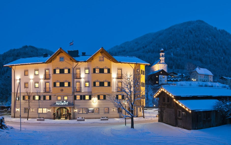 beleuchtetes Hotel Resl in Flachau im Winter mit Bergkulisse